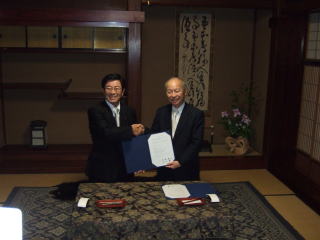 協定書に調印し握手する古田岐阜県知事と石井富山県知事