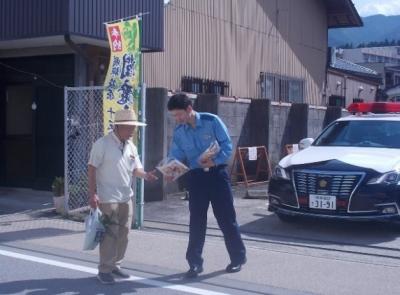 天領朝市で警察官がチラシを配る様子