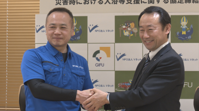 握手を交わすVネットの川上理事長と江崎知事